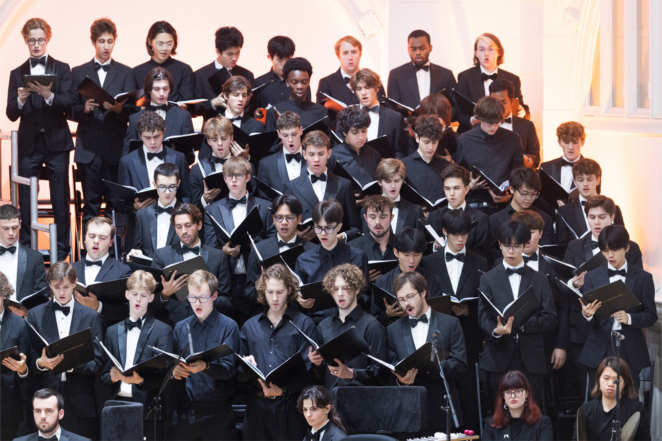 A group of male students singing in a choir.
